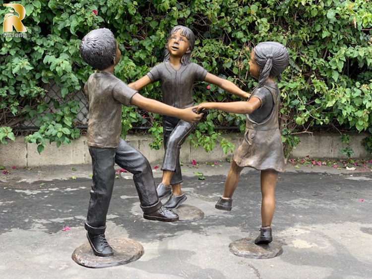 boy and girl on bench garden statue