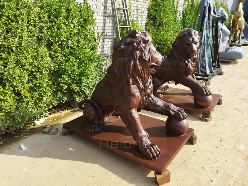 outdoor bronze lion statue with paw on ball (2)